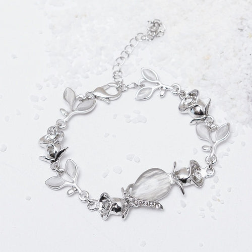 Silver bracelet with leaf and shell designs on a white background