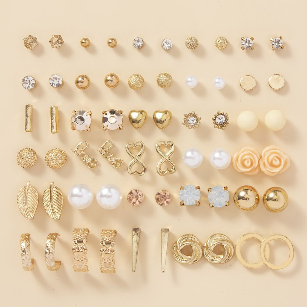 Collection of various gold and rose gold earrings on a beige background