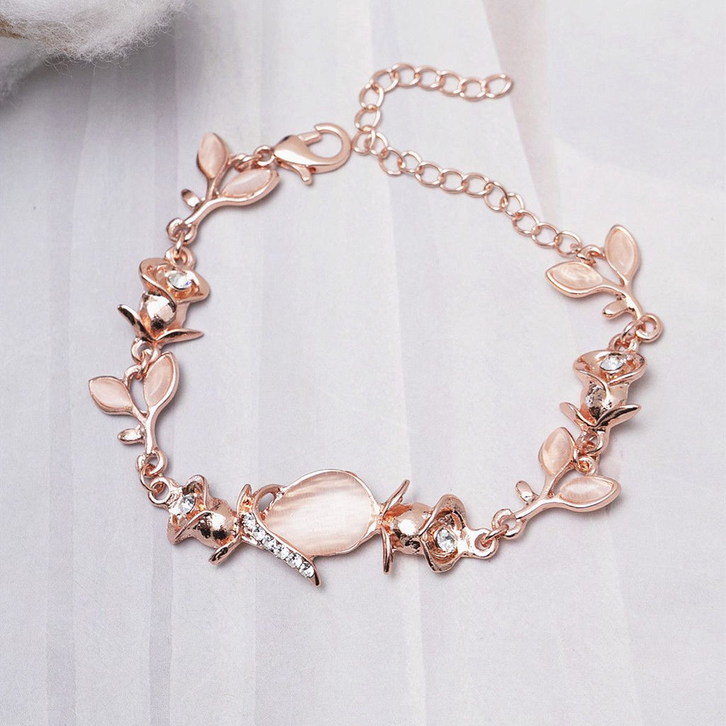 Rose gold bracelet with floral and fish designs on a white background